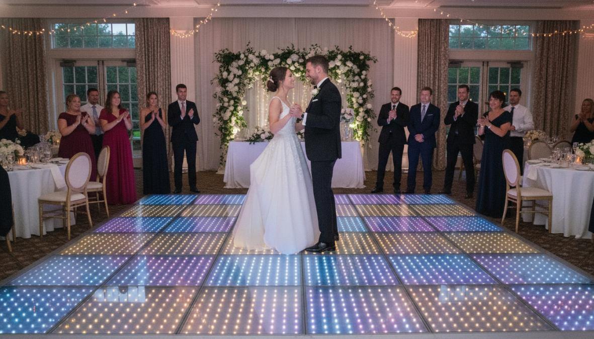 Bruidspaar dansend op een verlichte LED dansvloer tijdens een bruiloftsfeest, omgeven door gasten die toekijken, met disco-achtige blauwe en paarse LED-verlichting