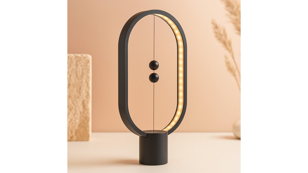 A cozy home setup with a glowing LED magnetic table lamp casting warm light on a wooden desk beside a small projector throwing a crisp image onto a white wall, warm ambient lighting filling the background