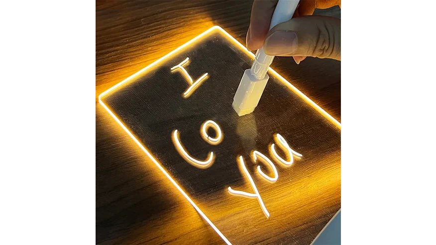 A tidy small desk in a compact flat with a laptop, a glowing charger lamp, a compact LED note board and a small plant, natural light from a window, no clutter