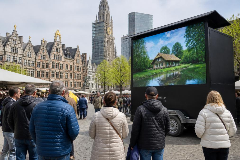 Een LED-scherm op een aanhangwagen tijdens een outdoor promotieactie op een marktplein in Antwerpen, met mensen die het scherm bekijken bij daglicht