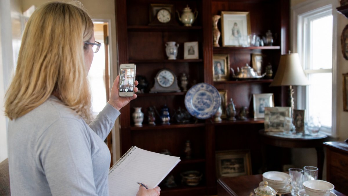 Family member taking photos of household items for an estate inventory when distributing personal property after death.
