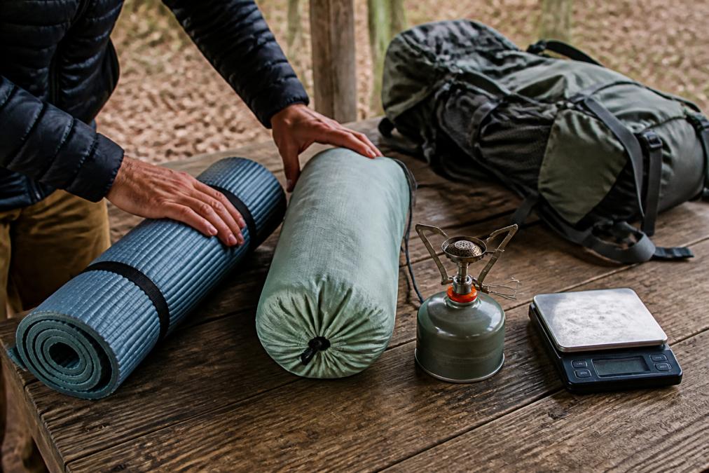 Infographic process for organizing lightweight gear for long distance hiking, featuring the big four essentials.