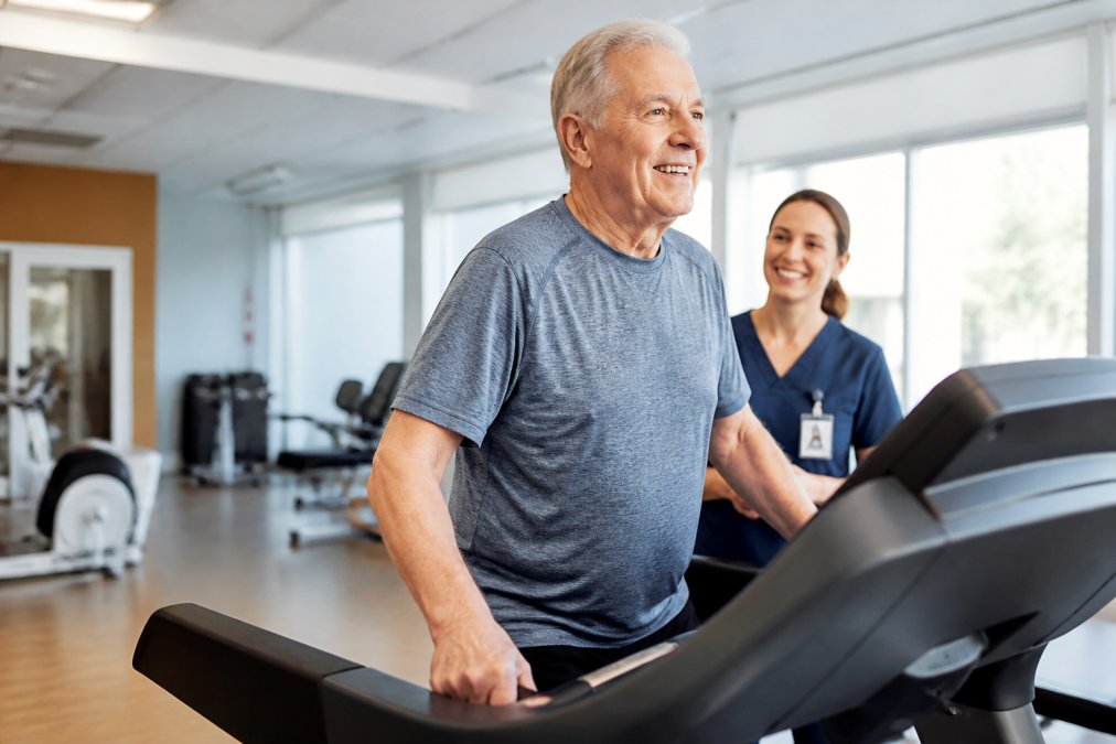 Heart surgery survivor walking on a treadmill in a cardiac rehab clinic to support their long term recovery