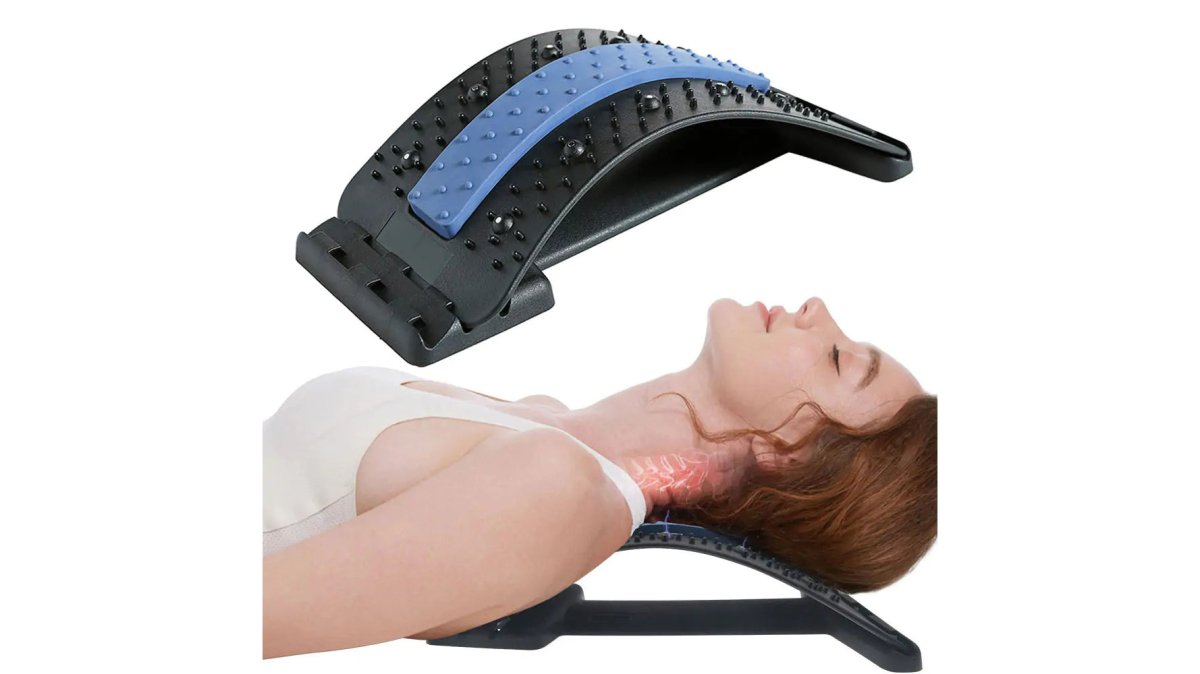 Remote worker seated at a compact desk with a lumbar support cushion positioned behind their back, wearing a wired headset, with a smartphone mounted on an adjustable holder, working comfortably in a bright home office with natural window lighting