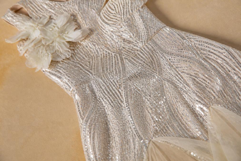 Close-up of premium luxury fabric textures showing intricate sequin beading, velvet weave, metallic finish, and satin sheen under soft evening lighting, highlighting refined craftsmanship