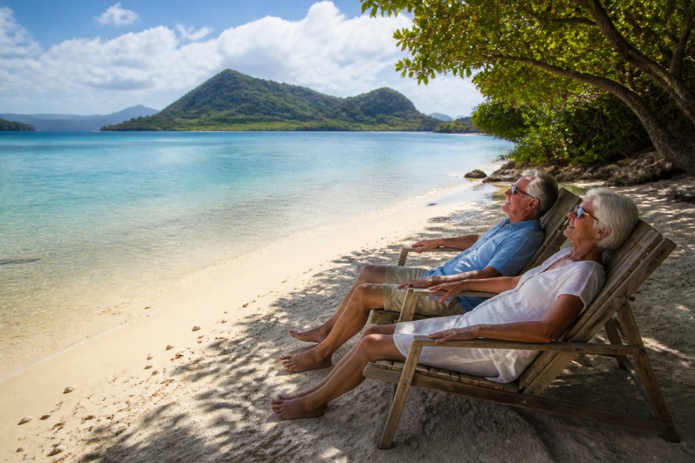 An older couple relaxing on a pristine, secluded beach in the Pacific, clear turquoise water and lush green islands in the background, enjoying a quiet sunny afternoon
