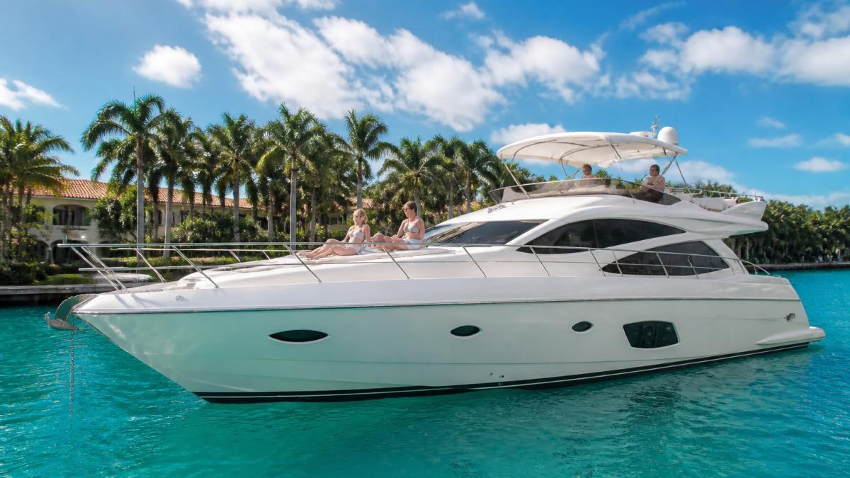 Guests relaxing on a luxury yacht anchored in turquoise South Florida waters for premium luxury yacht experiences