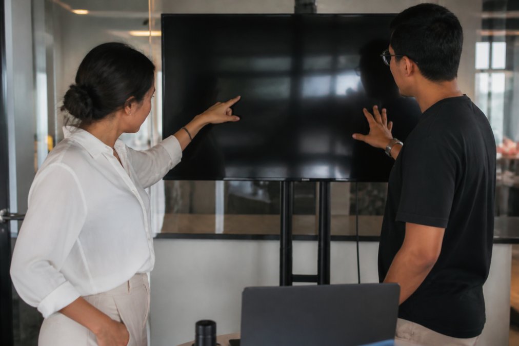 Project manager and developer reviewing real-time metrics for maintaining transparency in software outsourcing