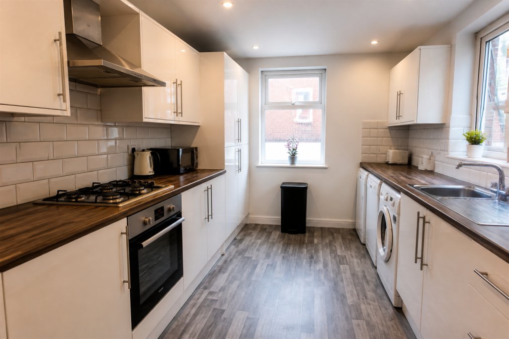 Interior of a well-maintained shared kitchen in an HMO property, showing modern appliances, adequate workspace, and clean facilities meeting standard requirements