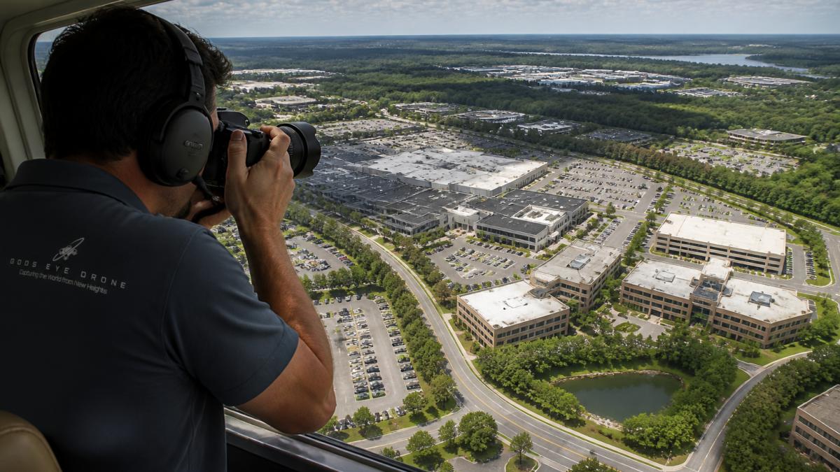 Expansive aerial view of a large commercial property with multiple buildings, parking lots, and surrounding landscape captured from high altitude showing extensive coverage area and fine detail
