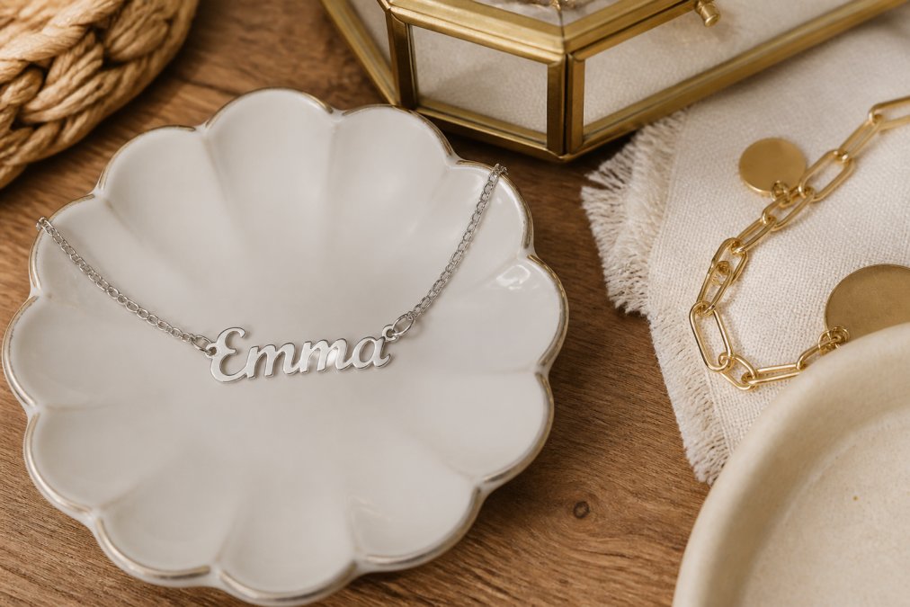 A collection of personalized jewelry and home goods displayed on a natural wooden surface, showcasing different gift styles with various material finishes and personalization details in warm, natural lighting