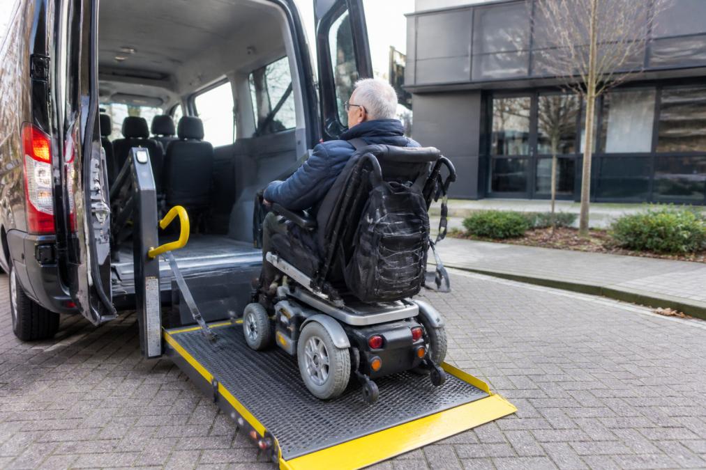 Interieur van aangepaste voertuig met uitgebreide laadklep, fixatiesystemen en veiligheidsgordels, elektrische scootmobiel in voertuig