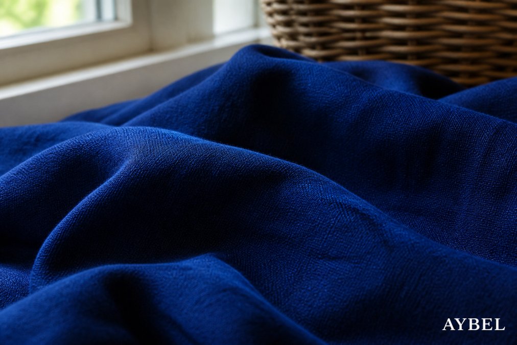 Primo piano di un tessuto di cotone di colore blu profondo appena fissato, che mostra una trama uniforme e una profondità di colore ricca, con una texture visibile illuminata dalla luce naturale da una finestra