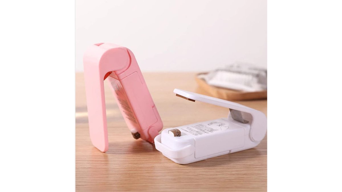 A close-up of a small kitchen counter with a flexible tap extender fitted to a standard sink tap, a compact digital scale spoon and a mini heat sealer arranged neatly beside a chopping board