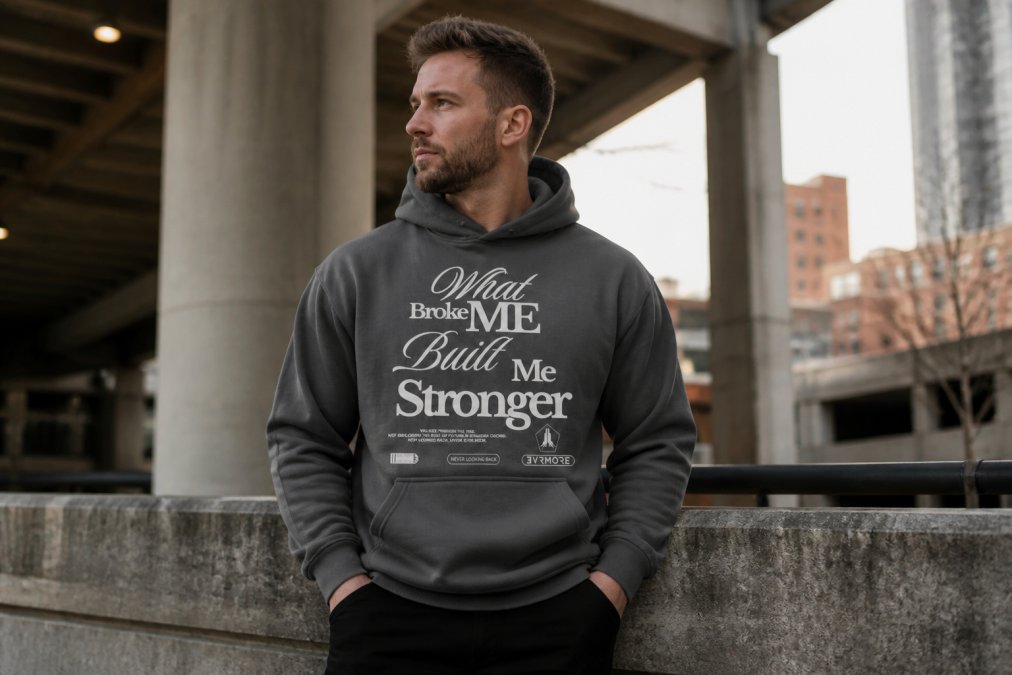 Person wearing minimalist heavyweight streetwear tee in neutral slate tone, standing confidently in natural daylight with relaxed boxy fit, clean aesthetic visible in calm urban setting