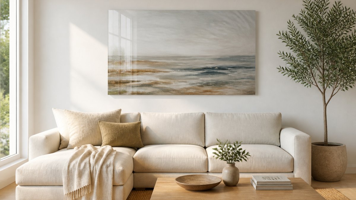 Large frameless acrylic art piece hanging above a neutral sofa in a bright modern living room with an olive tree