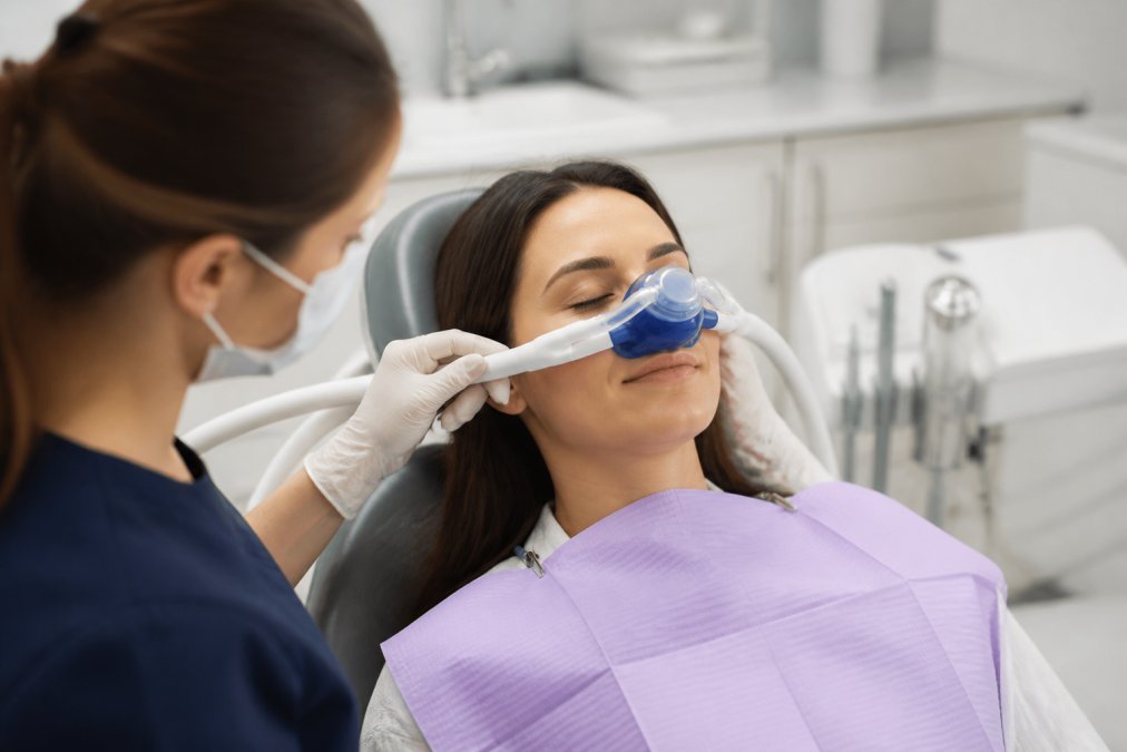 Calm patient using a nitrous oxide mask as part of modern dental techniques for comfort in a clinical setting