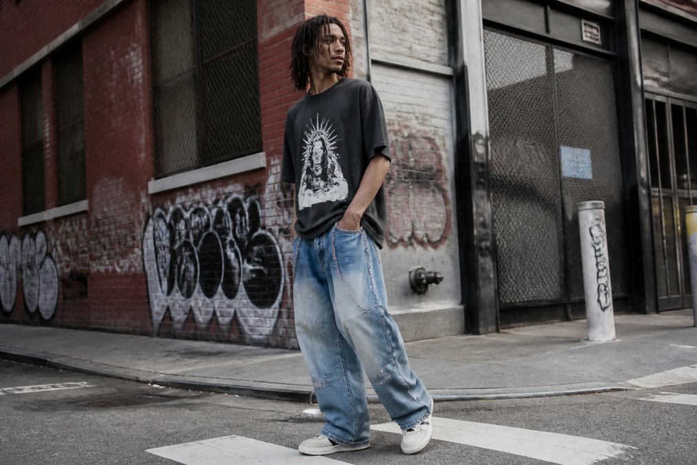 A stylish individual in an urban setting wearing an oversized graphic t-shirt and baggy denim, capturing the modern streetwear vibe