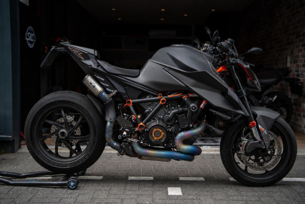Close-up van een luxe klassieke motorfiets in een donkere garage met aandacht voor details zoals het motorblok, originele chromen onderdelen en de tachometer