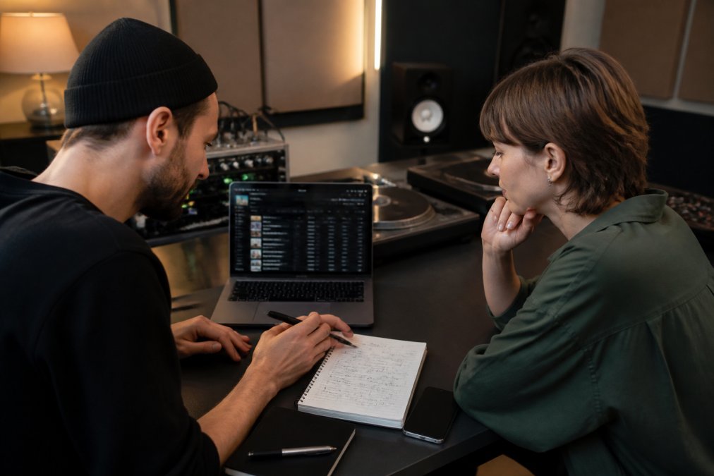 Electronic label owner and producer reviewing a release plan together at a studio desk
