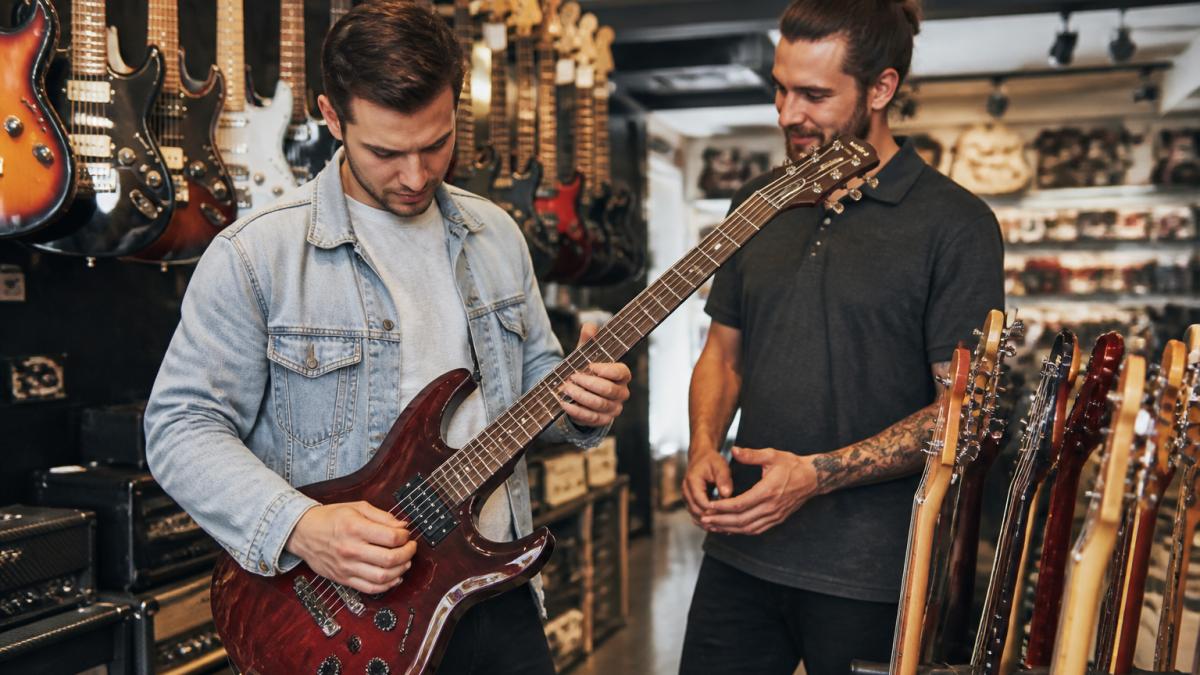 Musician receiving expert advice while browsing electric guitars at one of the best music retailers in Australia