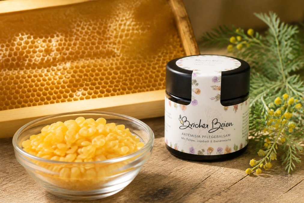Nahaufnahme von gelblichem Bienenwachs in einer Glasschüssel mit Bienenwabe im Hintergrund, warmes natürliches Licht von links, hölzerner Untergrund