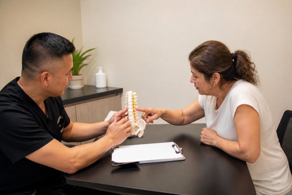 Healthcare provider and patient in consultation room reviewing treatment options together at a desk with medical charts and paperwork