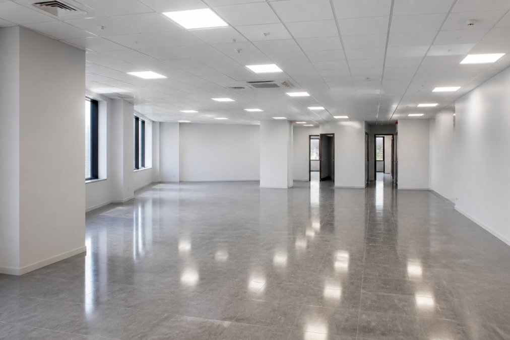 Empty, freshly restored office space with clean painted walls, polished floors, and restored lighting fixtures ready for lease surrender or new tenant occupancy