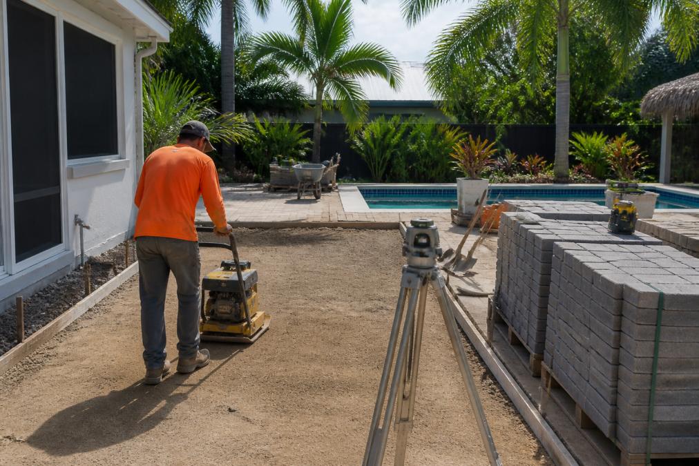 Outdoor Living Space Renovation Cost 2026: What to Budget 2 Diagram showing the paver patio installation process and renovation cost factors for a backyard base layer.