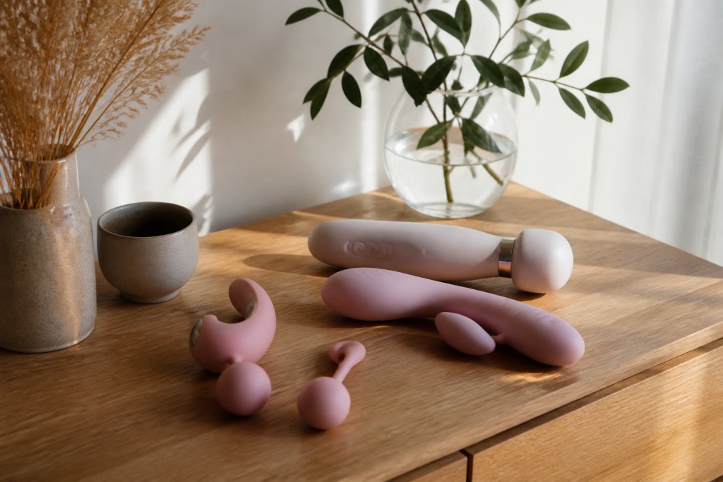 Elegante intieme producten in natuurlijk licht op minimalistisch houten oppervlak, met nadruk op verfijnde vormen en textuur, zacht diffuus daglicht