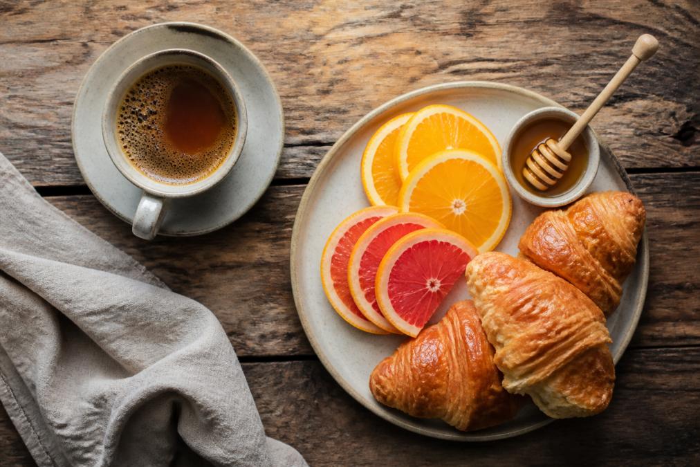 Infographic diagram pairing light roast coffee with croissants, citrus, and honey on a rustic wooden table