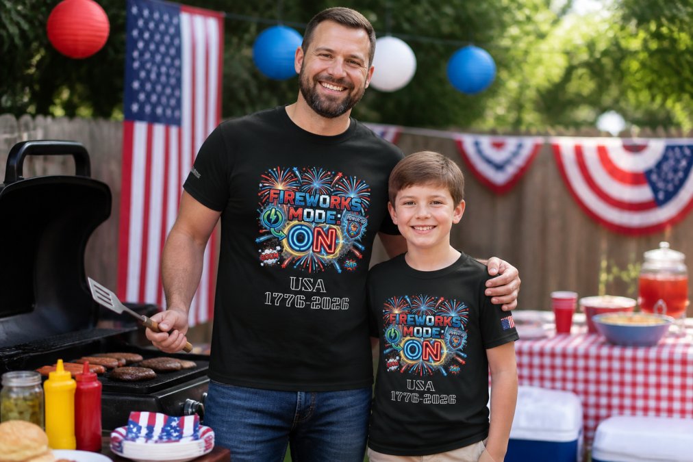 Parent and child wearing patriotic graphic tees with stars and stripes standing in front of a backyard barbecue setup with red, white, and blue decorations, natural daylight, both smiling