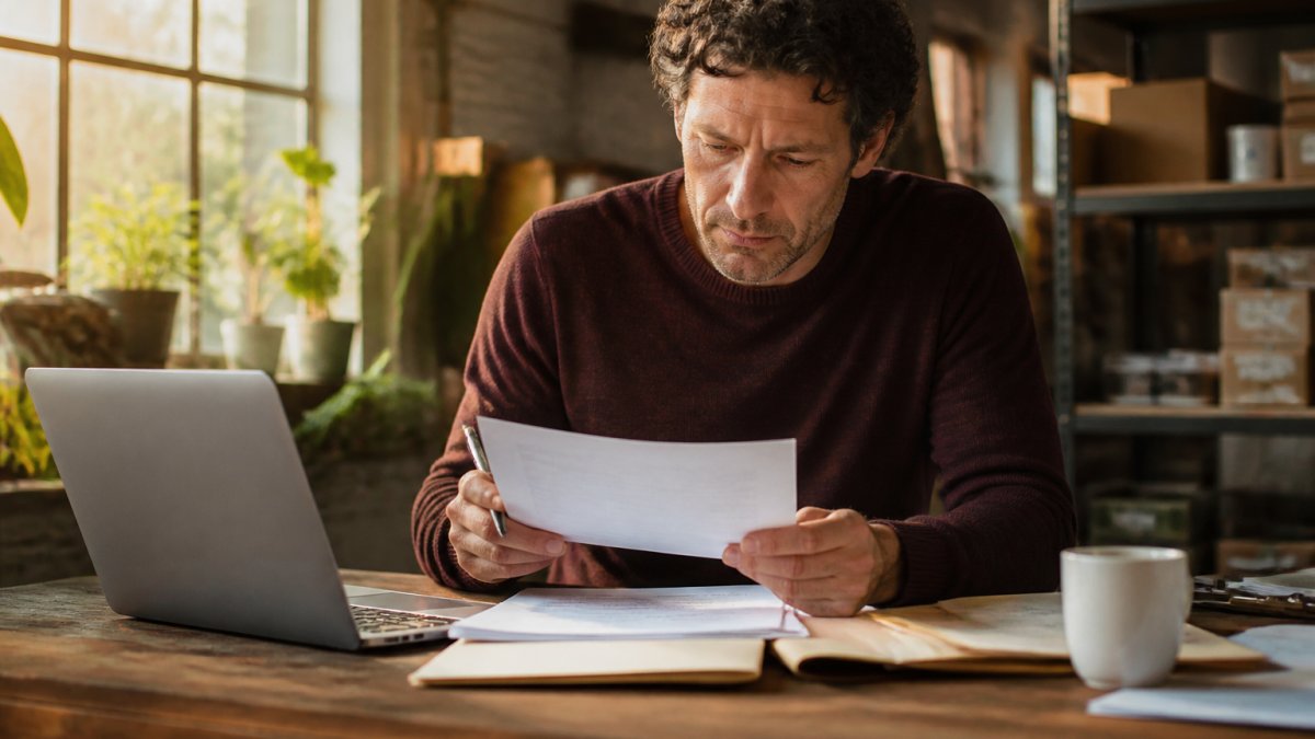 Startup founder reviewing employment documents for a PEO vs EOR transition in a modern, sunlit office space