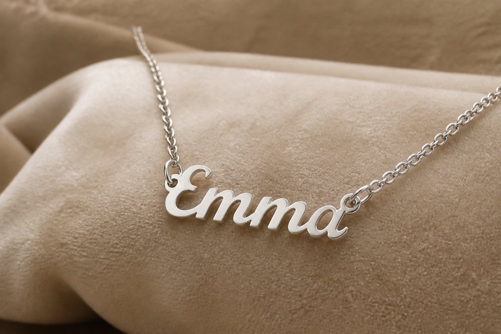 Close-up of an elegant personalized name necklace with delicate script lettering displayed on a luxurious velvet surface, soft warm lighting highlighting the polished metal finish and intricate craftsmanship details