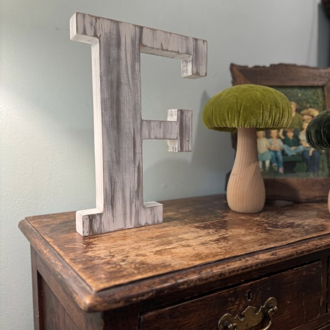 Weathered painted wood letter in a rustic foyer