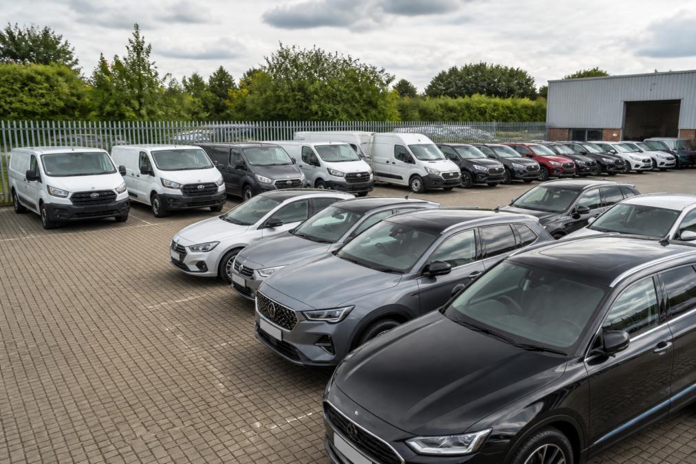 Modern fleet of mixed vehicles including vans, saloons, and SUVs parked in a structured depot with professional organisation and clear vehicle identification