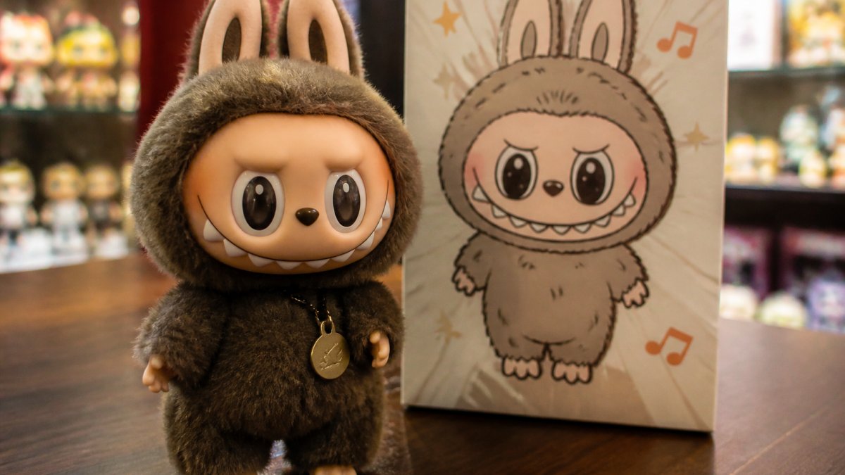 Close-up of authentic Labubu figure displaying detailed serrated teeth, pointed ears, and intricate character design with official Pop Mart packaging visible in background