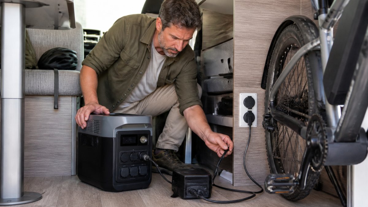 E-Bike-Ladegerät angeschlossen an eine tragbare Powerstation im Innenraum eines Wohnmobils.
