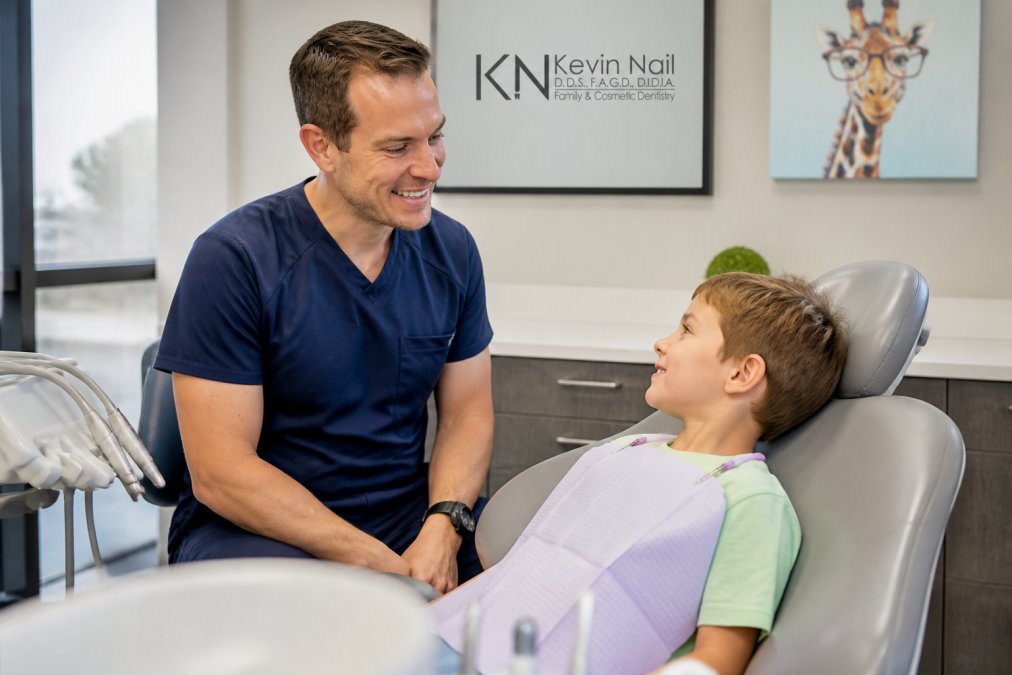Young child sitting in a dental chair with a friendly dentist nearby, the dental office bright and welcoming with colorful decorations, showing the calm environment and dental equipment