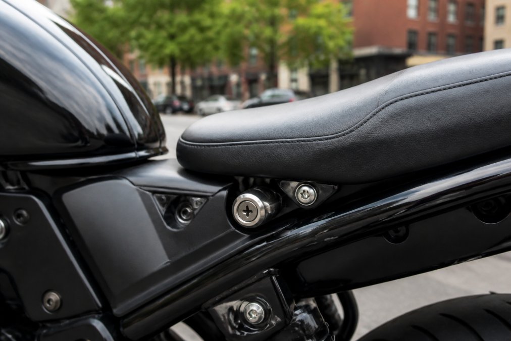 Close-up of a security lock installed on a motorcycle seat to prevent motorcycle seat theft on a city street.