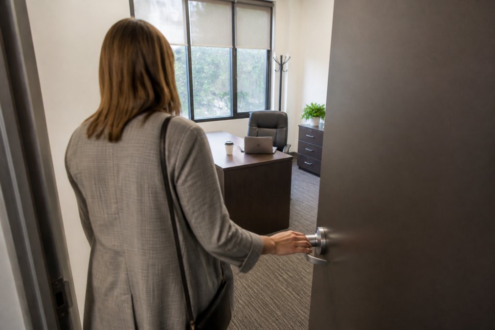 Business owner unlocking a furnished private office suite, perfect for comparing private office vs coworking.