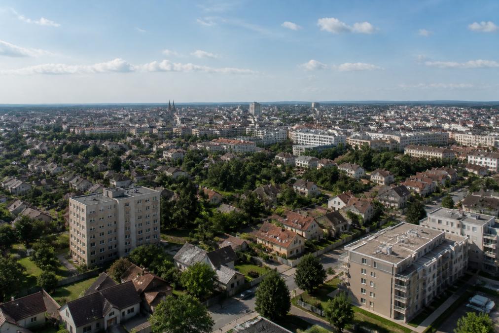 Vue aérienne montrant la diversité architecturale de Montluçon avec quartiers résidentiels, maisons individuelles, immeubles collectifs et espaces verts sous ciel dégagé