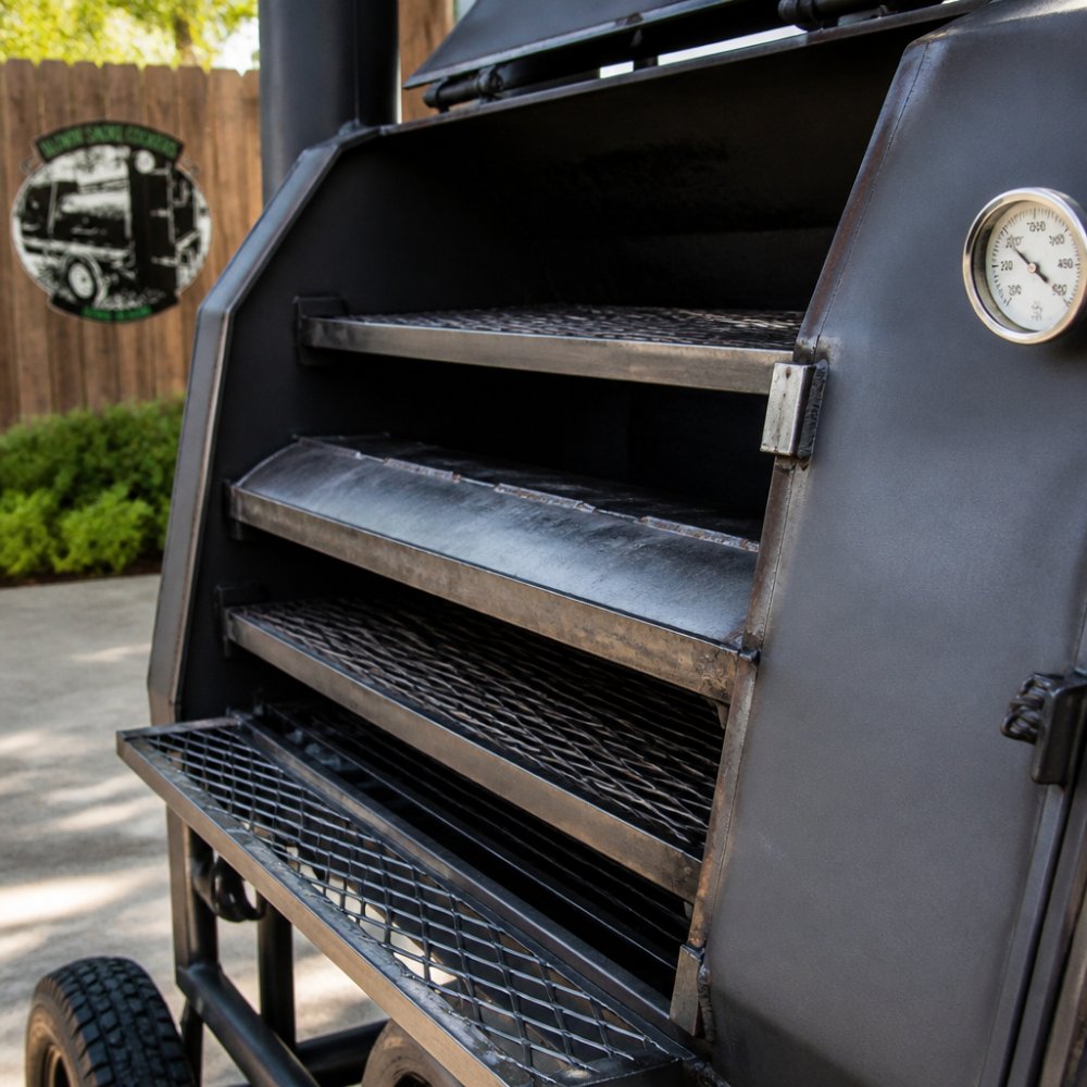 Close-up of reverse flow smoker's interior showing the baffle plate deflecting heat and smoke, with a thermometer visible on the cooking chamber door in a backyard setting