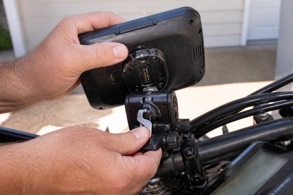 Rider engaging a metal locking lever on a Garmin Zumo XT mount while protecting Garmin Zumo from theft.