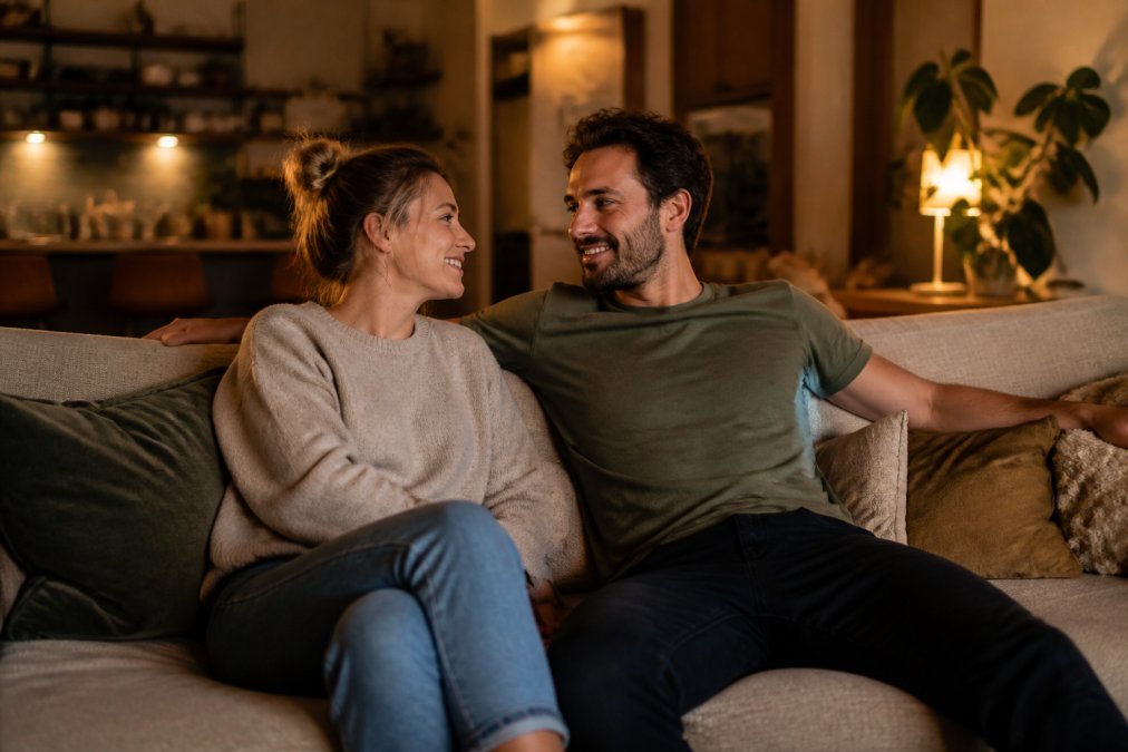 Koppel geniet van quality time op de bank om hun relatie te versterken na een drukke werkweek zonder telefoons.