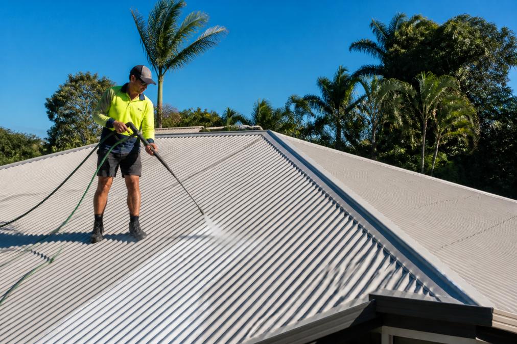 Professional exterior cleaners using a soft-wash lance on a Queensland home roof