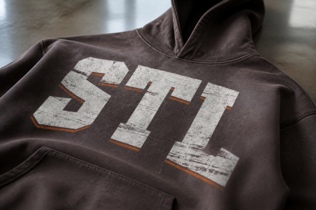 Close-up detail of raw seam construction and heavyweight cotton fabric texture on a boxy tee, showing craftsmanship and garment detail with natural studio lighting