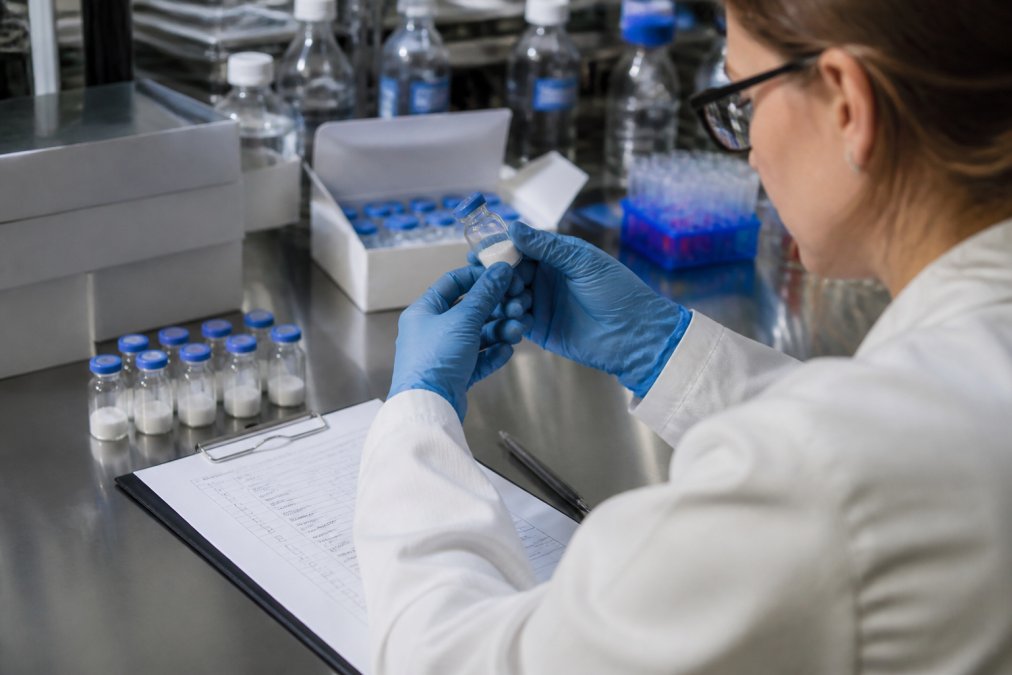 Researcher reviewing peptide vials and quality control documents for a peptide replacement guarantee claim