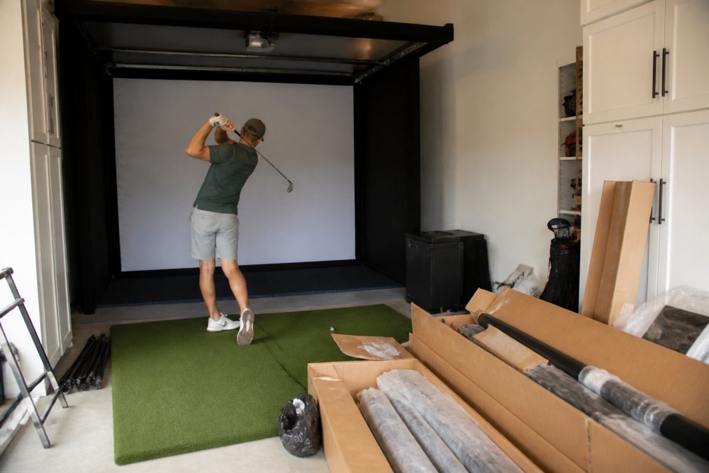 Professional illustration showing overhead and golfer and mid-swing concepts for retractable golf simulator enclosure