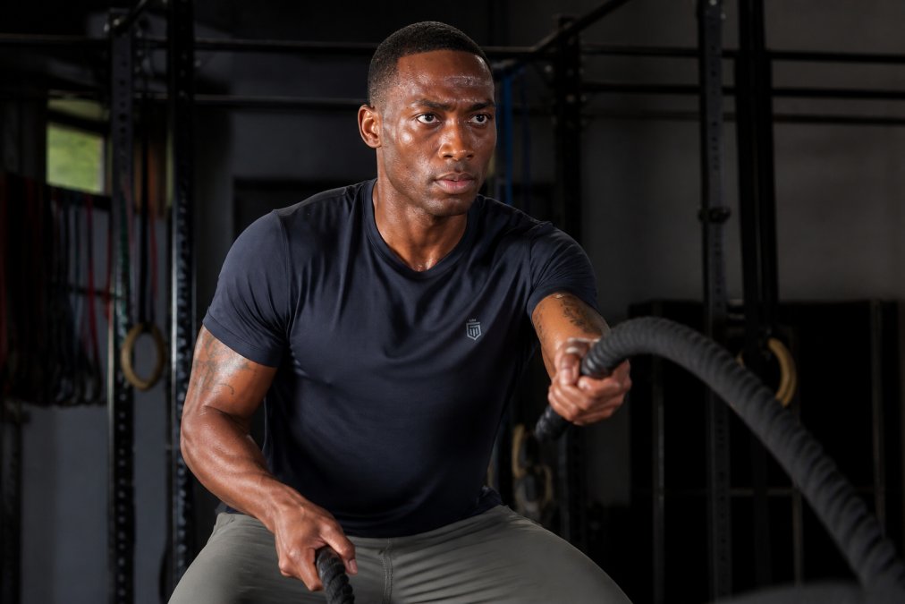 Athlete in motion during intense training, wearing premium athletic apparel, demonstrating durability and comfort during high-impact movement with visible muscle engagement